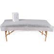 A disposable non woven bed sheet white, covering a full sized portable massage table draping the whole table 