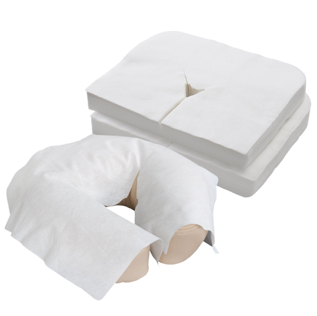 Soft cloth-like disposable face cradle covers shown stacked and placed over a massage table headrest cover on white background